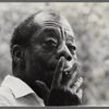 James Baldwin looking contemplative while smoking cigarette