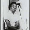 James Baldwin sitting with arms folded across torso