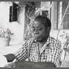 James Baldwin in checkered shirt marking pages