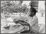 James Baldwin in checkered shirt marking pages