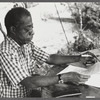 James Baldwin in checkered shirt marking pages