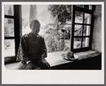 James Baldwin sitting at window