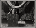 James Baldwin at podium with two microphones