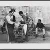 James Baldwin sitting on curb behind street vendor