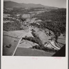 Air view. Dairy farm with hay stacks and cows in foreground. Lincoln, Vermont in distance. Lincoln, Vermont.