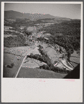 Air view. Dairy farm with hay stacks and cows in foreground. Lincoln, Vermont in distance. Lincoln, Vermont.