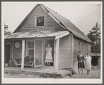 [Woman and two young girls standing in front of dilapidated house; probably Cape Cod, Massachusetts.]