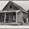 [Woman and two young girls standing in front of dilapidated house; probably Cape Cod, Massachusetts.]
