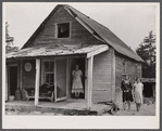 [Woman and two young girls standing in front of dilapidated house; probably Cape Cod, Massachusetts.]