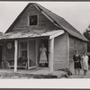[Woman and two young girls standing in front of dilapidated house; probably Cape Cod, Massachusetts.]