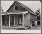 [Woman and two young girls standing in front of dilapidated house; probably Cape Cod, Massachusetts.]