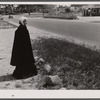 The hitchhiker. Decorative figure in old-fashioned dress in front of antique shop at entrance to Cape Cod near Bourne Bridge, Massachusetts.