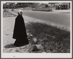 The hitchhiker. Decorative figure in old-fashioned dress in front of antique shop at entrance to Cape Cod near Bourne Bridge, Massachusetts.