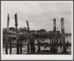 Ruins of former fish pier, Captain Jack's Wharf, a tourist colony which used to be a fish pier and the Pilgrim monument in the background. Provincetown, Massachusetts.