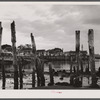 Ruins of former fish pier, Captain Jack's Wharf, a tourist colony which used to be a fish pier and the Pilgrim monument in the background. Provincetown, Massachusetts.