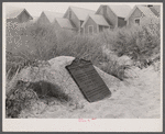 Commemorative plaque on Corn Hill where, supposedly, the Pilgrims first found sweet corn. In the background, tourist houses. Provincetown, Massachusetts.