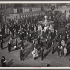 New York, New York. Installing the defense bond sales photomural prepared by the Farm Security Administration in the concourse of the Grand Central terminal. Crowd watching.