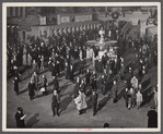 New York, New York. Installing the defense bond sales photomural prepared by the Farm Security Administration in the concourse of the Grand Central terminal. Crowd watching.