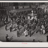 New York, New York. Installing the defense bond sales photomural prepared by the Farm Security Administration in the concourse of the Grand Central terminal. Crowd watching.