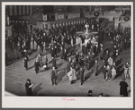 New York, New York. Installing the defense bond sales photomural prepared by the Farm Security Administration in the concourse of the Grand Central terminal. Crowd watching.