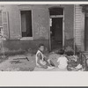 Slum front yard playground, Washington, D.C. Such is the front yard available to these two youngsters to play in.