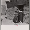 Two sisters and brother before their house. Great Western Sugar Company's beet sugar workers' colony at Hudson, Colorado. The father is dead, and the girls don't attend school because they're "too old," and the boy because he is "sick all the time".