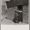Two sisters and brother before their house. Great Western Sugar Company's beet sugar workers' colony at Hudson, Colorado. The father is dead, and the girls don't attend school because they're "too old," and the boy because he is "sick all the time".