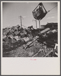 Washington, D.C. Scrap salvage campaign, Victory Program. Crane loads blocks of scrap metal onto a freight car in yard of wholesale junk company.