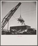 Washington, D.C. Scrap salvage campaign, Victory Program. Electro-magnet loads metal scrap onto freight car in wholesale junkyard.