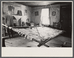 Elderly woman and girl with unfinished quilt in a suspended quilting frame. North Carolina?