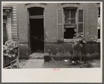 Front of Negro home near Capitol, Washington, D.C. Interiors of these homes vary little. A chair or two and a table, a bed and perhaps an extra mattress on the floor cares for six to ten people.