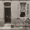 Front of Negro home near Capitol, Washington, D.C. Interiors of these homes vary little. A chair or two and a table, a bed and perhaps an extra mattress on the floor cares for six to ten people.