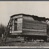 This one-room hut built of rough lumber over the chassis of an abandoned Ford truck was the housing provided by a landlord for an illiterate wood-cutter, with a wife and seven children.