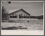 Rehabilitated client, Everett Tune, feeding chickens bought with rehabilitation loan, with laying house in background built by him with rehabilitation loan, Dent County, near Salem, Missouri.