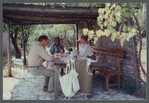 James Baldwin at bamboo-shaded table with guests at his home in France