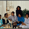 James Baldwin sitting with five women