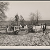 Wooden sleds drawn by tractor bringing supplies from main road to project at Berwyn, Maryland. During the winter months tractors and mud sleds furnish the only method of getting from the main road to the project.