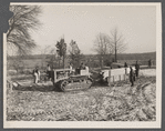 Wooden sleds drawn by tractor bringing supplies from main road to project at Berwyn, Maryland. During the winter months tractors and mud sleds furnish the only method of getting from the main road to the project.
