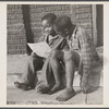 Manpower, junior size. Two barefoot junior commandos in Roanoke, Virginia, wriggle their toes with delight as they study their instructions for collecting scrap for Uncle Sam's great army.