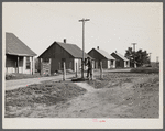 Street scene in the mining settlement of Zook Spur, Iowa, where part of the occupants of the Granger Homestead formerly lived. Each pump services four houses. Rent four dollars per month.