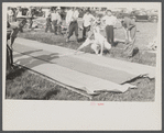 Firemen's muster. Boothbay center, Maine. Measuring the farthest drop of water on building paper which is unrolled fresh for each team. Distances were in the neighborhood of two hundred feet.