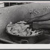 Field cook washing raw chicken parts