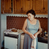 Older woman in sleeveless dress holding towel