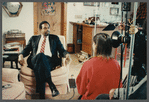 Man in suit and striped tie being filmed