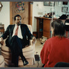 Man in suit and striped tie being filmed