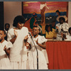 Two girls and woman in white singing at Central Holiness Church of God