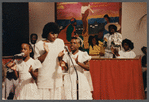 Two girls and woman in white singing at Central Holiness Church of God