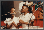 Two girls in white singing at Central Holiness Church of God