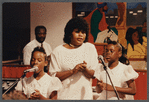 Two girls and woman in white singing at Central Holiness Church of God