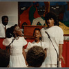 Two girls and woman in white singing at Central Holiness Church of God